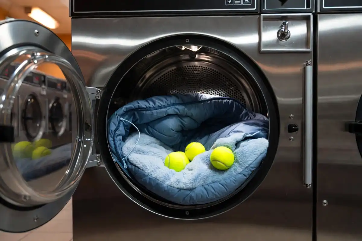 Sleeping bag in a tumble dryer with tennis balls for loft