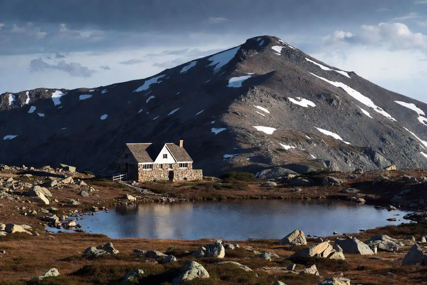 AMC Lakes of the Clouds Hut sitting beside an alpine pond below the summit of Mount Washington